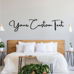 a bed with white sheets and pillows next to a wall that says your custom text