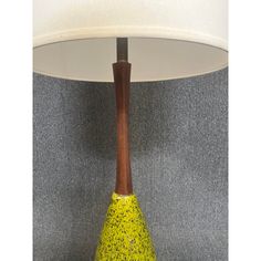 a yellow vase sitting under a white lamp