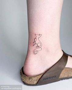 a woman's foot with a small tattoo on the side of her leg,