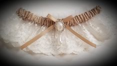 This vintage look garter is lovely in light ivory net lace over a champagne satin band. Decorated with a faux pearl and crystal finding. This garter is also available in plus size, just convo me with questions or your own design ideas! A blue satin rolled rose can be added to the inside of the band for your 'something blue'. Packaged in a view-top box tied with an elastic metallic bow, perfect for gift-giving or for safe-keeping after the wedding. Elegant Cream Lace For Wedding, Elegant Cream Lace For Bride, Elegant Beige Lace For Wedding, Fitted Cream Lace For Ceremony, Cream Fitted Lace For Ceremonies, Fitted Cream Lace For Wedding Night, Fitted Classic Lace For Wedding, Classic Fitted Lace For Wedding, Elegant Cream Wedding Lace