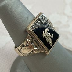 This large ring features an ornate, gold letter F centered in the onyx. A .015ct diamond is set in the corner of the ring face. This ring is covered in ornate gold details, including the face, the shoulders and around the top of the ring. The head of the ring is a substantial 13 x 16.4mm and the shank is 3.6mm wide. Size 8. We can resize rings for a fee, so please inquire! Gold Onyx Ring, Initial F, The Ring Face, Signet Ring Men, Gold Letter, Ring With Diamond, Letter F, Large Ring, Men's Jewelry Rings