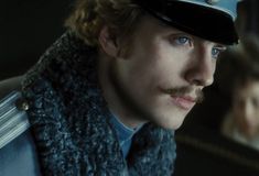 a man wearing a hat and scarf in the movie night at the museum, with blue eyes