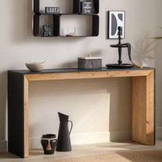 a wooden table topped with black shelves filled with vases and other decorating items