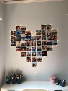 a white desk topped with a heart shaped photo collage next to a wall filled with pictures