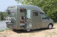 an rv parked next to a body of water