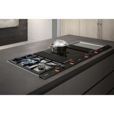 a black stove top sitting on top of a counter next to a pot and pan