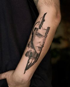 a man's arm with a tattoo on it that has an image of a woman holding a knife