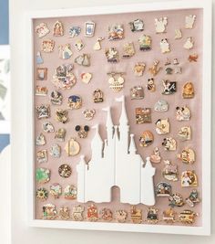 a white frame filled with lots of pins and magnets on top of a wall