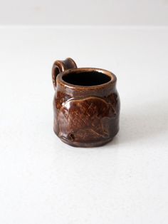 a small brown vase sitting on top of a white table