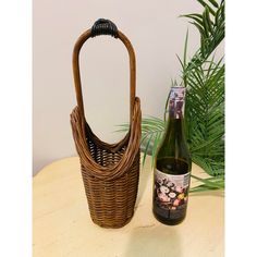 a bottle of wine sitting next to a wicker basket on top of a table