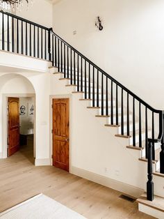 a staircase leading up to the second floor in a house with white walls and wood floors