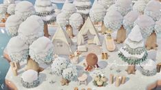 an animated winter scene with snow covered trees and small houses in the middle of it