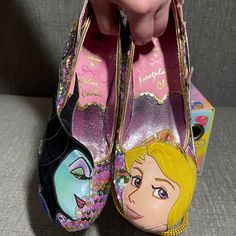 Irregular Choice X Disney's Sleeping Beauty Touch The Spindle! Heels. Limited Edition From The Disney Princess Collection. Pastel Rainbow Sequin Upper Mid-Heel. One Shoe Features Aurora Applique On The Toe With Pink Castle Applique On The Side, Pink And Blue Glitter And A Heel Made To Resemble Her Crown. The Other Shoe Features Maleficent Applique On The Toe, Her Raven Diablo On Her Staff On The Side Amid Purple Glitter Flames And A Heel With Even More Flame Applique. Gold Heel Cap. Cushioned Inner. Exclusive Printed Soles. Flame Applique, Disney Princess Collection, Irregular Choice Shoes, Pink Castle, Disney Sleeping Beauty, Princess Collection, Irregular Choice, Heel Caps, Gold Heels