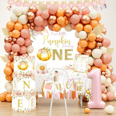 an orange, pink and white birthday party with pumpkins on the front door frame