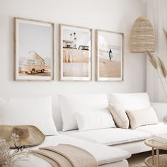 a living room filled with white furniture and pictures on the wall above it's couch