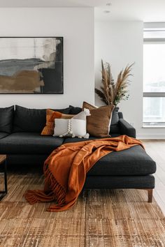 a living room filled with furniture and a large painting on the wall above it's couch