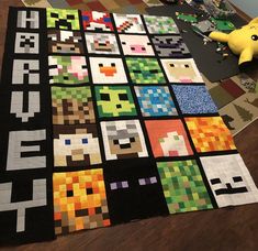 a quilt made to look like video game characters on the floor next to a stuffed animal