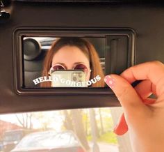 a woman taking a selfie with her camera in the back seat of a car