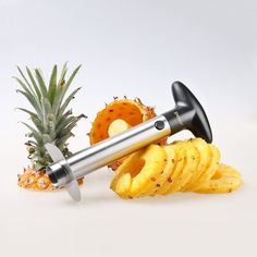 a pineapple peeler is laying next to some cut up fruit