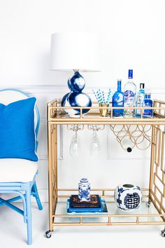 a blue and white bar cart with bottles on it, next to an advertisement for booze