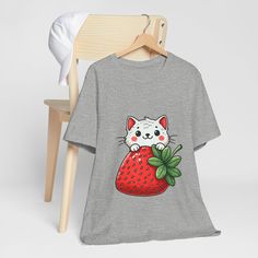 Embrace your love for adorable cats and strawberries with this charming unisex T-shirt featuring a cute kitty peeking over a vibrant strawberry. This fun and whimsical design is perfect for animal lovers and those who enjoy unique and playful fashion. Made from high-quality fabric, this comfortable tee is ideal for casual outings, lounging at home, or gifting to your favorite cat enthusiast. The detailed print showcases the cute cat's expression and the strawberry's vivid colors, making it a standout piece in your wardrobe. We utilize the authentic Bella Canvas 3001 brand, renowned for its UNISEX design, making it one of the most sought-after shirts in the market. Prior to placing an order, kindly refer to our size chart. It can be located in both the listing's images and description. This Cute Short Sleeve T-shirt With Cat Print, Cat Expressions, Whimsical Cats, Unisex Design, Gifts For Pet Lovers, Cat Art, Quality Fabric, Cute Cats, Casual Wear