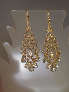 "Swarovski Crystal Filigree Earring Swarovski Crystal rhinestone filigree earrings. These stunning earrings feature large gold plated filigree with Swarovski Crystal rhinestone dangles. Earrings approximate length of 2 1/2\" from top of goldplated earwires and a width of 3/4\" across widest part. Arrives gift boxed. If you are looking for lightweight earrings that make a big statement, these earrings are for you! Perfect for the bride, bridesmaids, or that special occasion - an elegant and timel Bride Earring, Big Earrings Gold, Gold Filigree Earrings, Bride Earrings, Crystal Dangle Earrings, Earring Gold, Filigree Earrings, Jewelry Fashion Trends, Jewelry Lookbook