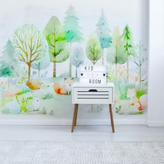 a room with a wall mural that has forest animals on it and trees painted on the wall