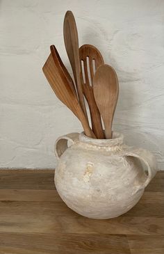 wooden utensils and spoons in a white vase