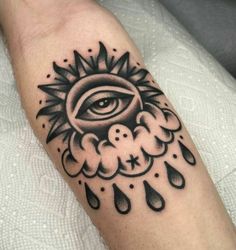 a black and white tattoo with an all seeing eye in the rain on someone's arm