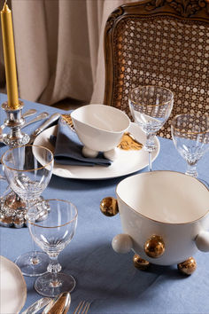 the table is set with dishes, silverware and gold - plated utensils