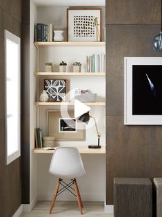 a white chair sitting in front of a wooden shelf filled with books and other items