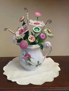 a vase filled with lots of flowers on top of a table