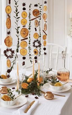 a table set for christmas with plates and silverware on it, surrounded by festive decorations