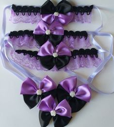 three purple and black garters with pearls on the top one has a bow