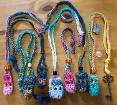 several crocheted lanyards are laid out on a wooden table with keys