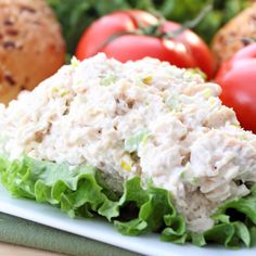 tuna salad with lettuce and tomatoes in the background, on a white plate