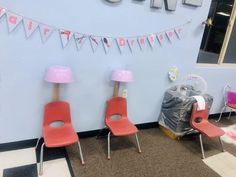 two red chairs sitting next to each other in front of a blue wall with letters on it