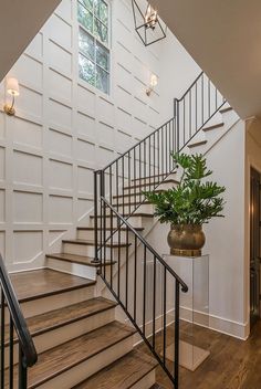 a plant is sitting on the stairs in this house