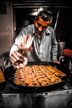 a man cooking food on top of a grill