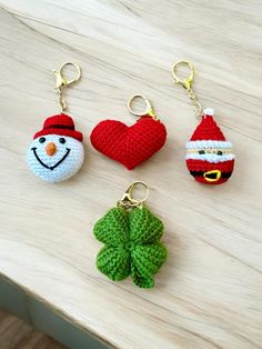 four crocheted keychains with christmas decorations on them sitting on a table