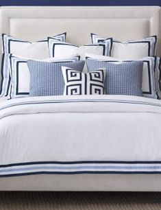 a bed with blue and white pillows on it