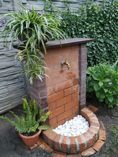 a brick fire place surrounded by plants and rocks