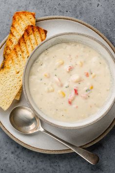 a bowl of soup with bread on the side