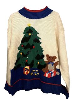 a sweater with a christmas tree on the front and presents under it, as well as a teddy bear