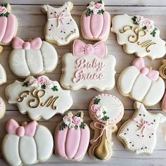 baby shower cookies decorated with pink and white icing are arranged on a wooden surface