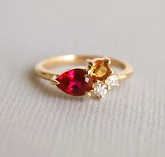 Indulge in vibrant joy with the Bella ring. A lab-created ruby, known as an affordable alternative to natural untreated ruby, is the focal point of this cluster-style ring. Complemented by natural citrine and lab-grown diamonds, this ring is perfect for July birthdays or anyone who loves bold and colorful jewelry. ---------------------- DETAIL ✦ MAIN STONE： Lab-Created Ruby ✧ Shape： Pear ✧ Cut: Faceted ✧ Clarity: Eye Clean ✧ Size/Weight： 7 x 5 mm/0.7 ct. approx. Ring Cluster, Ring Ruby, Ring Birthstone, Citrine Ring, Red Band, Natural Citrine, Colorful Jewelry, Diamond Cluster Ring, Gorgeous Jewelry