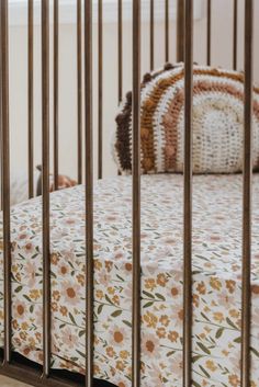 the baby is laying in his crib next to the pillow on the bedding