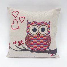 an owl is sitting on a branch with hearts in the sky behind it, embroidered onto a pillow