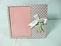 a pink and white photo frame with a giraffe decoration on the front side