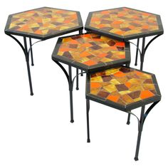 three tables with orange and yellow mosaic tiles on them, each topped with metal legs